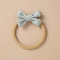 Detailed close-up of a soft light blue knitted bow attached to a tan elastic hair tie - Light Blue Knit Bow (6)