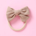 Détail d'un bandeau bébé en nylon souple avec un nœud en tweed de couleur kaki texturé - 10,5*7,5 cm / Café
