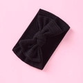 Detailed close-up of a black knitted baby headband with a large handmade bow knot - Black