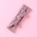 Gros plan du bandeau bébé en tissu nid d'abeille avec détail de nœud rose doux - Rose racine de lotus
