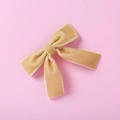 Vue détaillée d'une barrette à cheveux en velours caramel sur fond rose pastel - Jaune Gingembre (6)