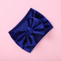 Detailed texture of royal blue velvet bow headband for infants on pink background - Sapphire Blue