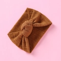 Detailaufnahme des karamellbraunen Baby-Stirnbands aus Rippstrick mit Knoten-Design - Braun