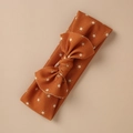 Close-up of baby headband with white sun pattern and large bow on burnt orange fabric - Sun Caramel Style (15)