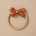 Close-up of rust orange bow hair band with white sun patterns and knitted texture - Rust Orange Sun Print Bow (14)