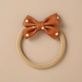 Close-up of caramel fabric bow with white polka dots on a seamless nylon baby headband - Caramel White Polka Dot Bow (17)