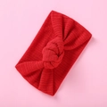 Rotes geripptes Baby-Stirnband mit elastischem Knotendesign auf einem rosa Hintergrund - Rot