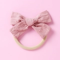 Detail eines rosa Stoffschleifen-Stirnbands mit Polka-Dot-Struktur und Gummiband - Braun