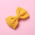 Dettaglio della trama in cotone mussola del fiocco per capelli color giallo zenzero - Curcuma