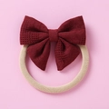 Détail d'un bandeau bébé avec un nœud à carreaux rouge foncé sur bande nylon - Rouge Foncé