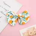 Detail of child bow hair clip with orange citrus print on white cotton fabric - White Background Kumquat