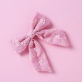 Dettaglio del fiocco rosa in cotone con ricamo floreale bianco e design a coda di rondine - Rosa