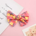 Dettaglio del fiocco per capelli in cotone con stampa di agrumi su tessuto rosa - Sfondo Rosso Frutta