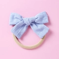 Detail eines weichen violetten Jacquard-Schleifen-Baby-Stirnbands mit Nylonband - Hellblau