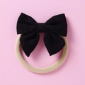 Détail du bandeau bébé avec nœud noir à texture gaufrée sur nylon beige doux - Noir