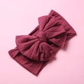 Close-up of soft wine red nylon baby headband with a large decorative bow detail - Wine Red