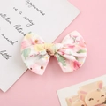 Dettaglio del fermaglio per capelli bimba con fiocco in cotone a fiori su sfondo rosa - Sfondo Rosa Chiaro Floreale