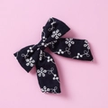 Gros plan détaillé d'un nœud papillon en coton bleu marine avec broderie florale - Noir