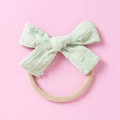 Detail eines mintgrünen Jacquard-Schleifen-Stirnbands mit weichem Nylonband für Babys - Blassgrün