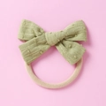 Detail eines Baby-Nylon-Stirnbands mit salbeigrüner strukturierter Baumwollschleife - Grün