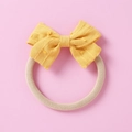 Detail of yellow cotton bow baby headband with textured dots on soft nylon elastic band - Yellow