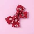 Detail view of red cotton bow hair clip with intricate white floral embroidery patterns - Red