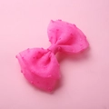 Détail d'une pince à cheveux nœud en tulle rose néon avec pois texturés - Rose rouge