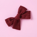 Close-up of a handmade dark red cotton hair clip with textured floral and grid patterns - Dark Red