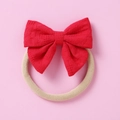 Détail d'un bandeau bébé en dentelle rouge avec ruban en nylon doux sur fond rose - Rouge