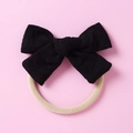 Détail du nœud à carreaux noirs avec élastique blanc crème sur un fond rose pastel - Noir
