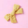Close-up of mustard yellow handmade cotton bow hair clip with fine hollow texture - Yellow