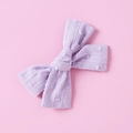 Close-up of lavender cotton jacquard bow clip with 3D polka dots and stripe textures - Purple
