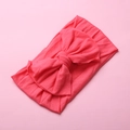 Close-up detail of soft elastic pink nylon headband featuring a large knotted bow design - Watermelon red