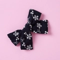Detailed close-up of dark blue cotton lace bow hair clip with white floral embroidery - Black