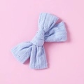 Close-up of light blue cotton bow hair clip with textured polka dots on pink background - Light Blue