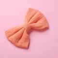 Dettaglio della trama in mussola di cotone rosa pesca del fiocco per capelli da bambina - Arancione Chiaro