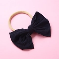 Détail d'un bandeau pour bébé en nylon souple avec un grand nœud noir en tissu doux - Noir