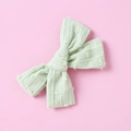 Detailed texture of a mint green cotton jacquard bow clip with raised polka dot pattern - Pale Green