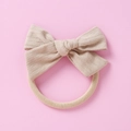 Détail d'un bandeau bébé en coton gaufré avec nœud et bande élastique souple - Gris rosé