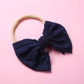 Détail d'un nœud en tricot bleu marine et bandeau en nylon beige pour bébé - Bleu Marine
