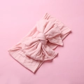Close-up of soft pink nylon baby headband with large double-layered swallowtail bow knot - Flesh Pink