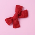 Close-up of red cotton jacquard bow hair clip with textured stripes and embossed dots - Red