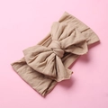 Detail of soft nylon baby headband with large swallowtail bow in nude color texture - Nude