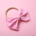 Gros plan détaillé d'un bandeau pour bébé en nylon souple avec un nœud en coton rose - Rose Pastel