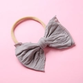 Détail du bandeau en nylon pour bébé avec un nœud gris tricoté sur fond rose - 13 Gris