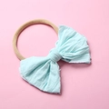 Détail d'un nœud en coton bleu clair sur un bandeau de bébé en nylon beige doux - Bleu Ciel