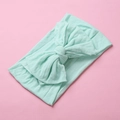 Close-up of mint green soft nylon baby headband with a large decorative double bow - Verdant