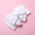 Close-up of soft white nylon baby headband featuring a large double-layered bow detail - White
