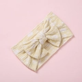 Gros plan d'un bandeau bébé en maille jaune avec motifs cœurs et un grand nœud - Jaune Éclatant Petites Fleurs