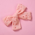 Détail de la pince à cheveux noeud rose avec broderie florale ajourée en coton doux - Orange Clair